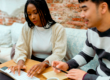 Dois colegas de trabalho conversando e sorrindo em um ambiente corporativo, representando a importância da amizade no trabalho para um ambiente profissional mais leve e produtivo.